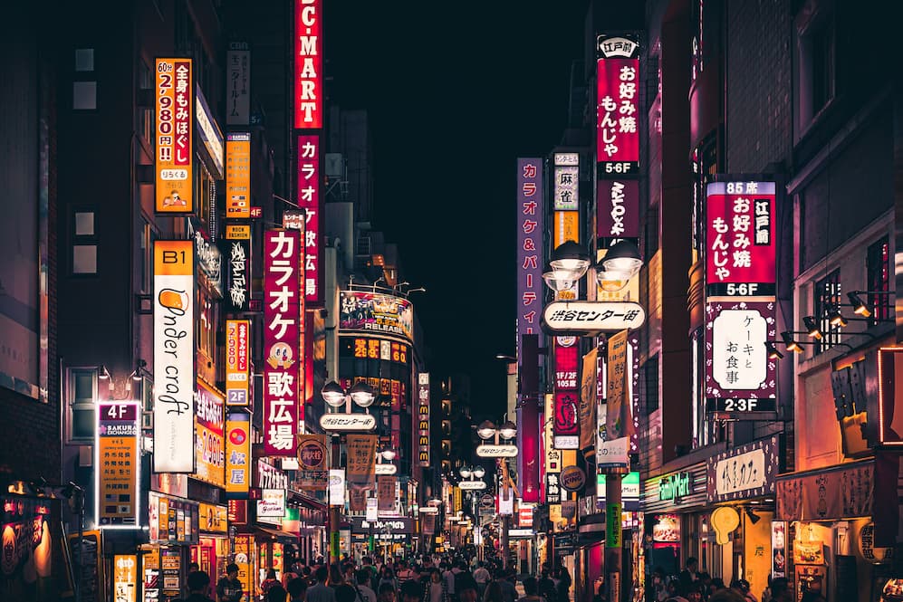 A colorful night view of the signs that line the streets of Shibuya