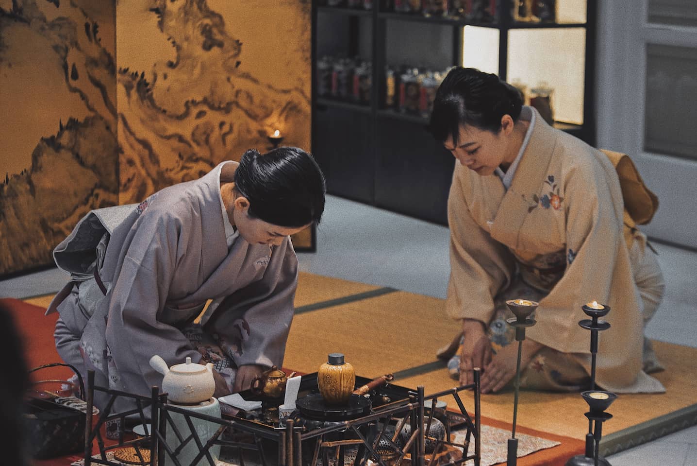 Two women wearing kimono and bowing to each other in a Japanese tea ceremony
