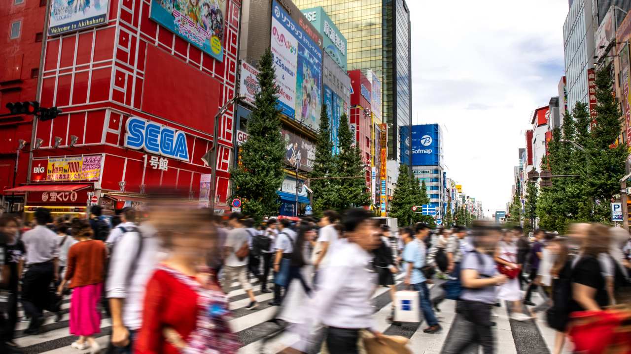 People crossing the road surrounded by buildings and things to do in Akihabara