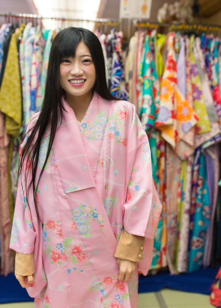 Woman wearing a pink kimono with a weaving floral design in a kimono store