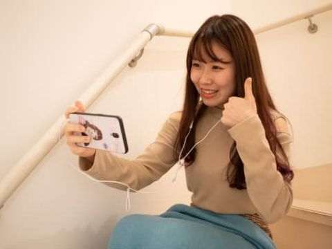 Japan Switch - Teacher using her smartphone to give a lesson and giving the thumbs up