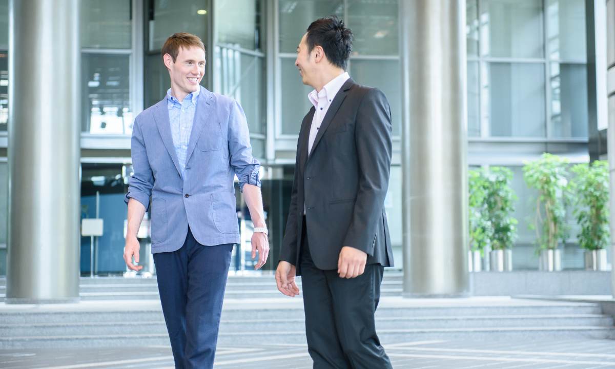 Two buisnessmen in suits having a casual conversation