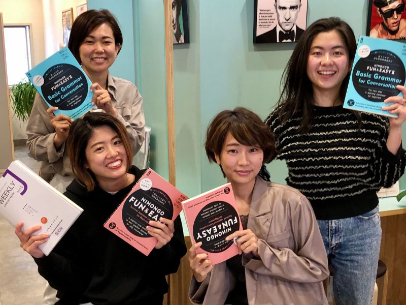 Japanese language school staff holding Japanese textbooks
