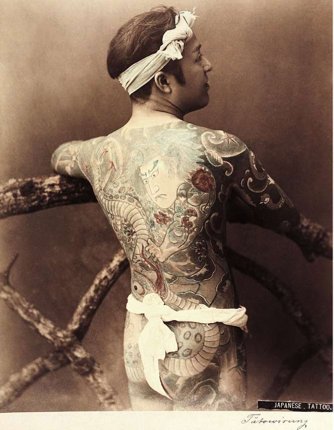 Old photo of Japanese man showing back covered in tattoos