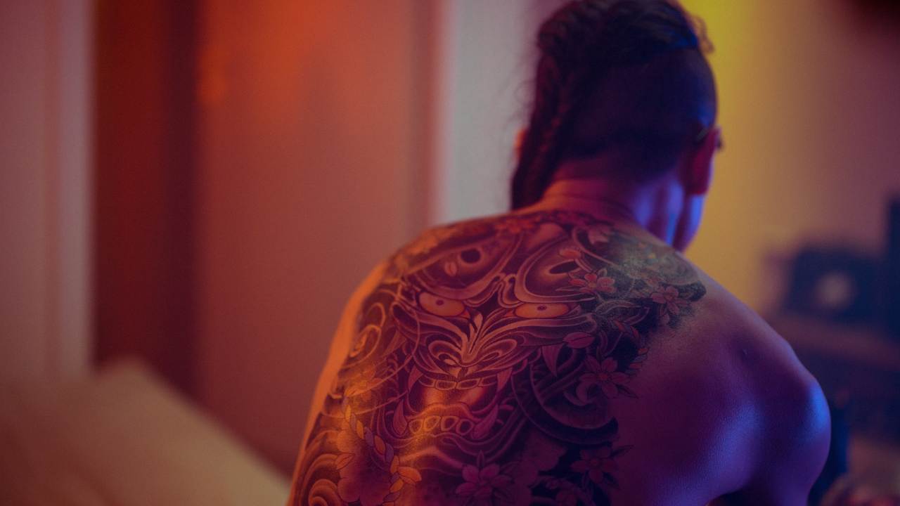 Man with back tattoo and long hair
