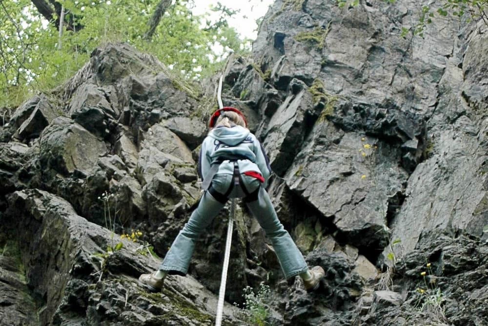 A woman climbing up a pathway via a chain