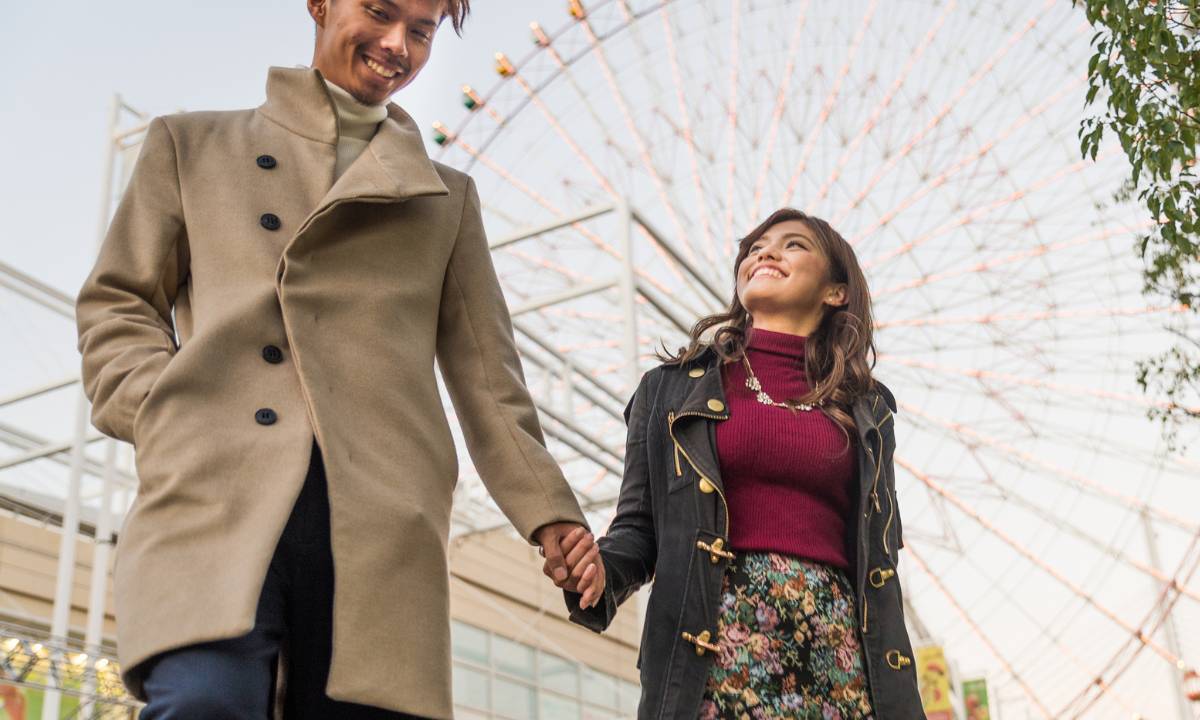 japanese couple holding hands with ferris wheel in background - i love you in japanese