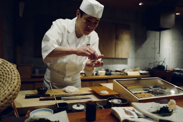 sushi chef preparing a piece of nigiri