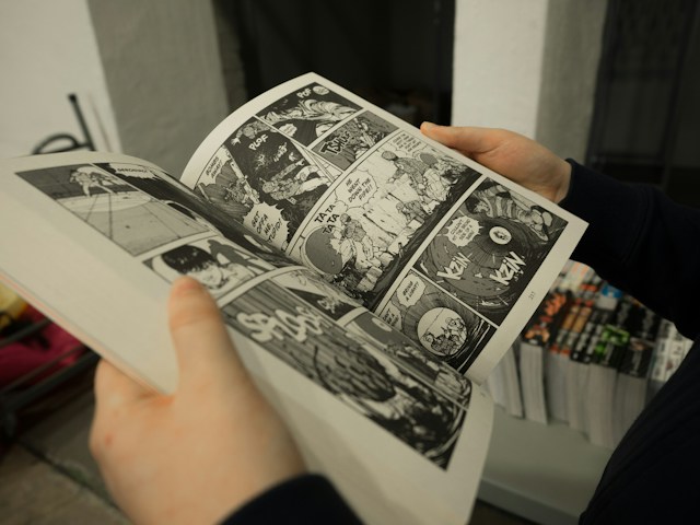 Person holding a manga book translated in English of old anime, Akira