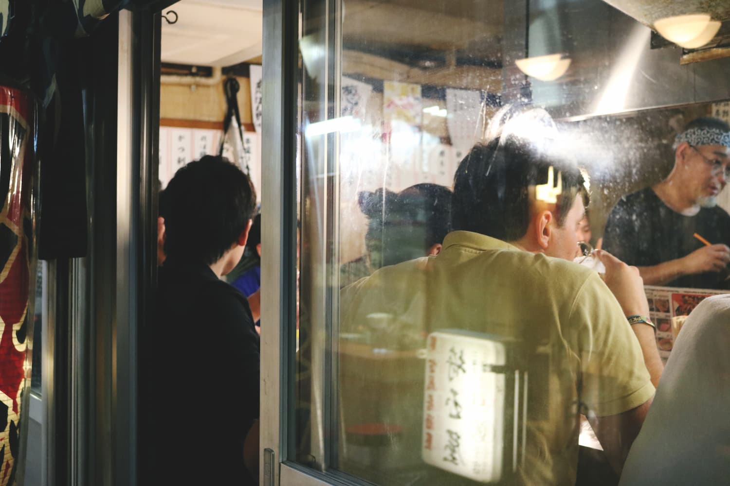 Japanese men eating at a small Izakaya restaurant in Shinjuku at night