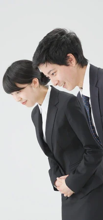 two individuals bowing after receiving meishi