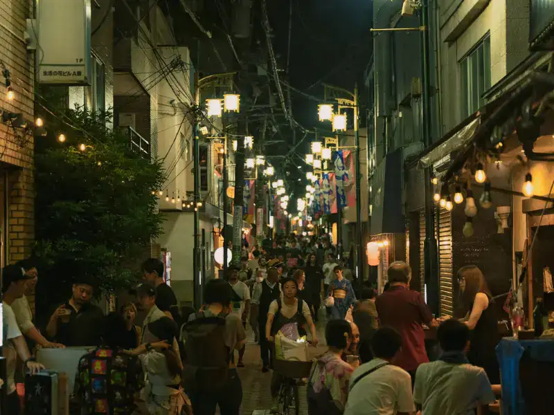 People walking down street at night in Koenji, Tokyo