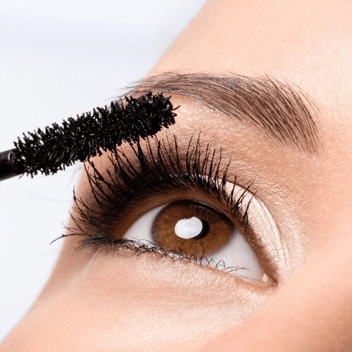 Close-up image of an eye with mascara being applied to the eyelashes