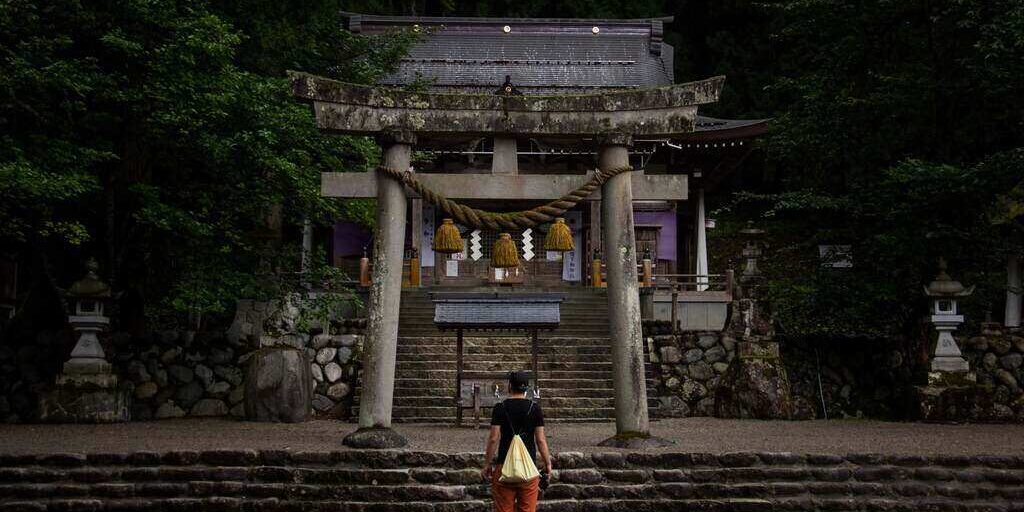 tourist showing respect in shrine entrance in japan