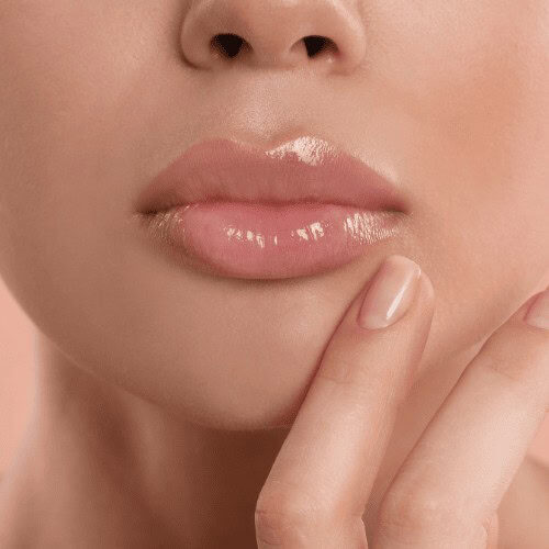 A close-up image of lips with a tinted balm and the hand of the lady over her chin showing her lips